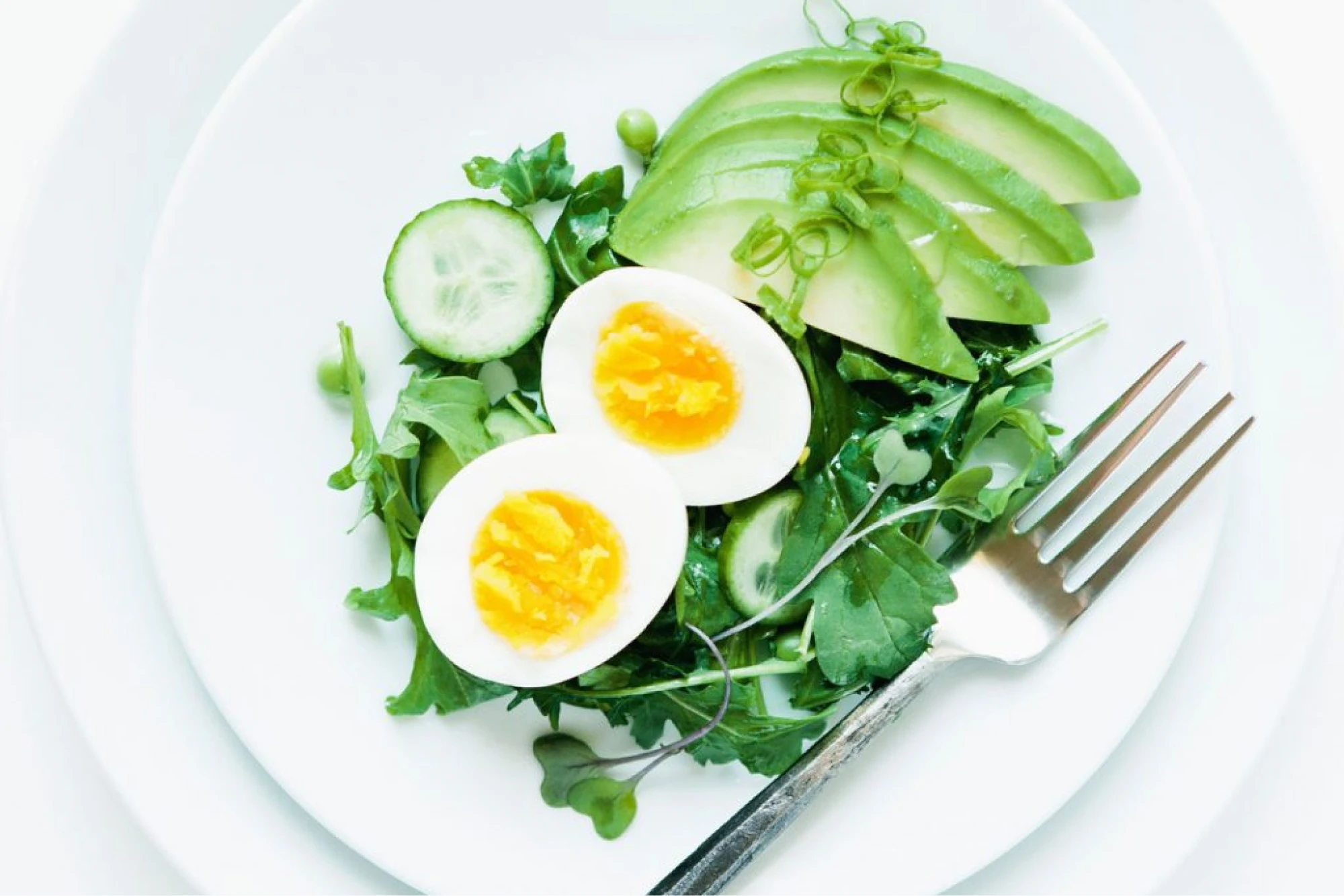 flat lay of plate of green vegetables and an egg